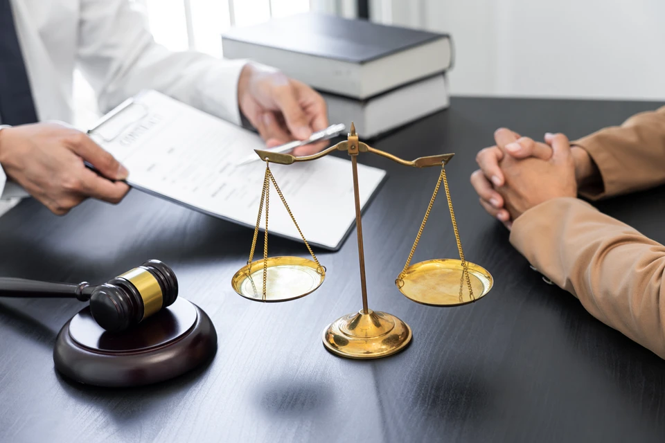 Sc&egrave;ne de consultation juridique dans un bureau avec avocat pr&eacute;sentant des documents &agrave; un client