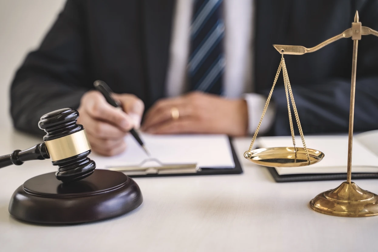 Scène de bureau juridique avec avocat en costume cravate rédigeant des documents